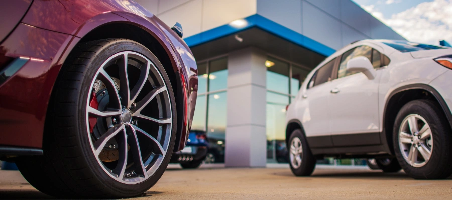 closeup of cars with dealership building in background